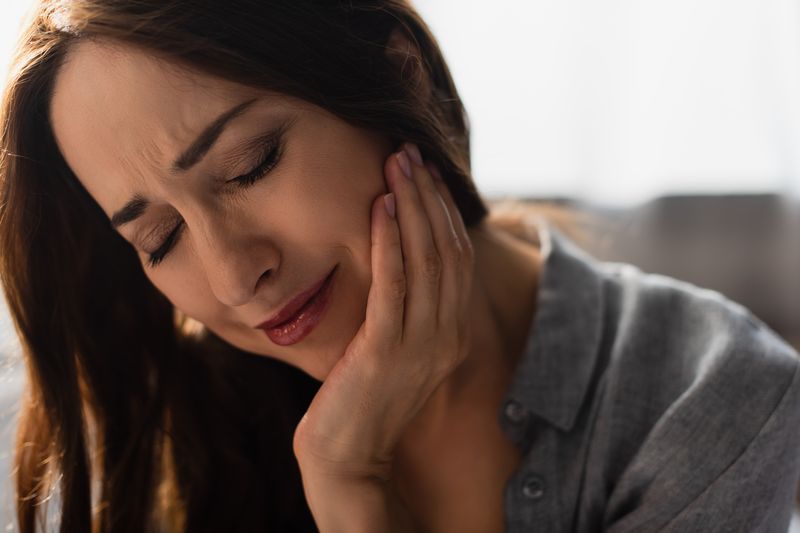 distressed woman experiencing painful toothache at