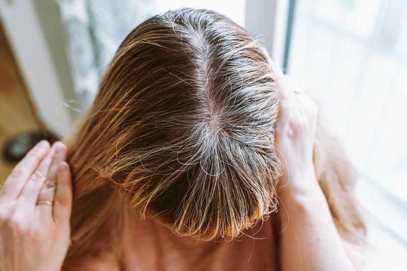 woman showing hair roots at home
