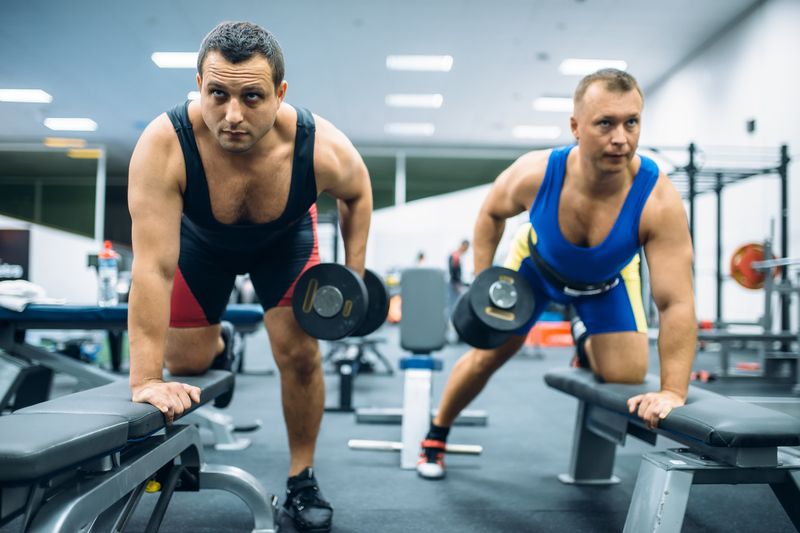 athletic men lifting weights at the gym