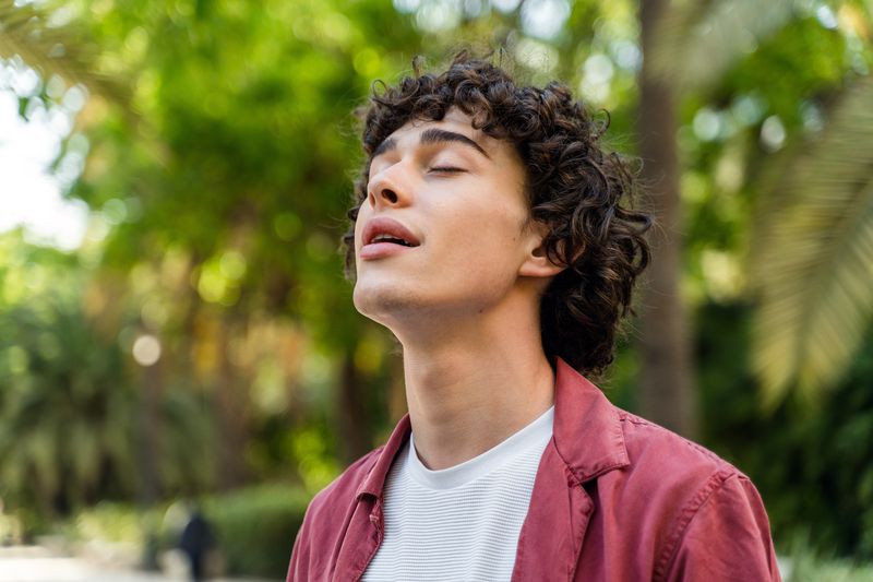 man with curly hair enjoying a peaceful moment out