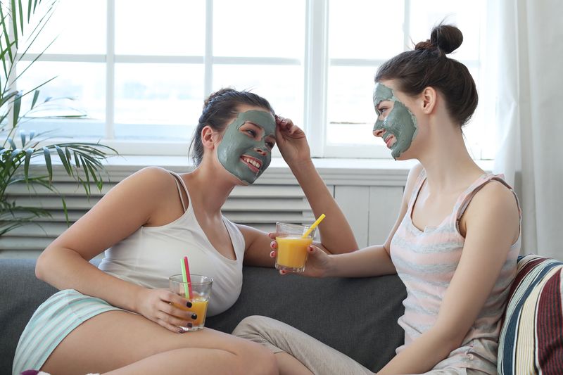 two women enjoying facials and refreshments at hom