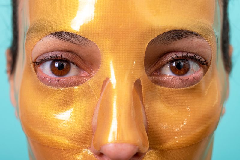 woman with a sparkling gold facial mask