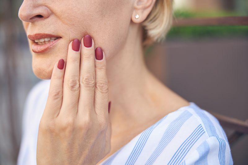 woman with red nails and lips close up
