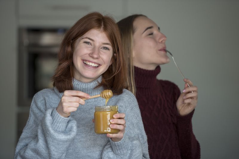 young women enjoying a sweet honey snack