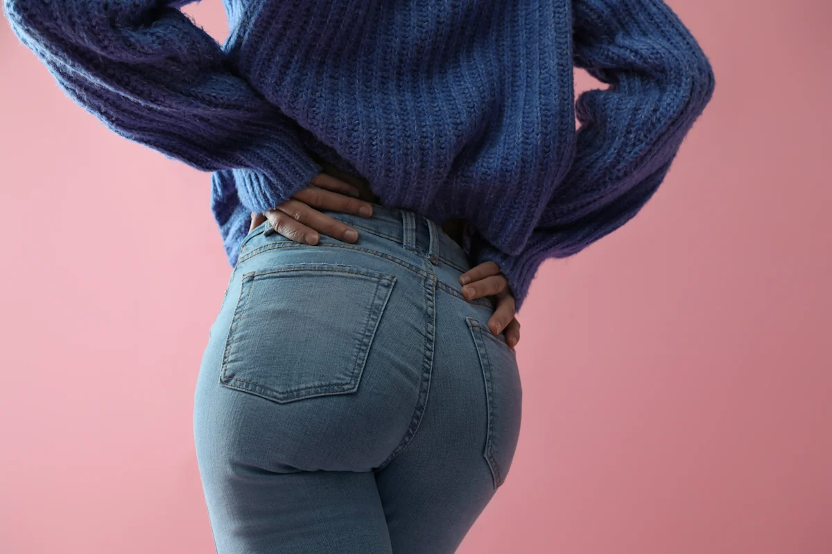 Une femme qui porte un jean qui met en valeur ses fesses
